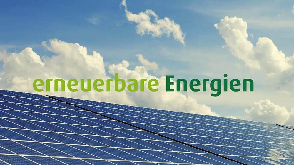 Photovoltaikmodule im Anschnitt gegen blauen Himmel mit Quellwolken, darüber die Einblendung erneuerbare Energien